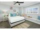 This cozy bedroom features a large bed, window seating, and a ceiling fan for added comfort at 8312 E Mackenzie Dr, Scottsdale, AZ 85251