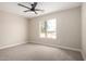 Well-lit bedroom with ceiling fan, carpet, and large window at 8773 W Pineveta Dr, Arizona City, AZ 85123