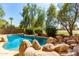 Relaxing freeform pool surrounded by rocks and lush greenery at 968 S Western Skies Dr, Gilbert, AZ 85296