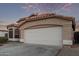 Front view of a tan house with a white garage door at 9765 W Pontiac Dr, Peoria, AZ 85382