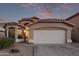 Tan house with a white garage door and landscaped yard at 9765 W Pontiac Dr, Peoria, AZ 85382