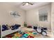 Bedroom for children featuring alphabet rug, drum set, toys, and a ceiling fan at 10029 E Tahoe Ave, Mesa, AZ 85212
