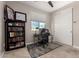 This bedroom features a large window, a ceiling fan, and is currently being used as a home office at 10029 E Tahoe Ave, Mesa, AZ 85212