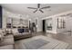 Open-concept living room with modern ceiling fan, recessed lights, gray sofa and view of the kitchen at 10029 E Tahoe Ave, Mesa, AZ 85212