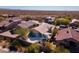 Aerial view of home with tile roof, desert landscaping, large patio with built in grill and lounge furniture at 10282 E Trailhead Ct, Gold Canyon, AZ 85118