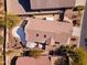 Aerial view of home with a large stone patio, mature landscaping, tile roof, and pergola-covered spa at 10282 E Trailhead Ct, Gold Canyon, AZ 85118