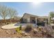 Desert landscaped backyard featuring large stone patio, covered patio and BBQ at 10282 E Trailhead Ct, Gold Canyon, AZ 85118