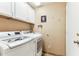 Functional laundry room with white washer, dryer and cabinets at 10282 E Trailhead Ct, Gold Canyon, AZ 85118