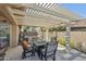 Cozy outdoor patio under a pergola with a tile table, seating, and a BBQ at 10282 E Trailhead Ct, Gold Canyon, AZ 85118