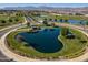 Aerial view of a community pond with landscaping and a small building nearby at 11444 N Northfield St, Surprise, AZ 85388
