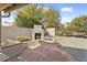 Relaxing backyard with a brick patio featuring an outdoor fireplace and low-maintenance landscaping at 15406 W Pinchot Ct, Goodyear, AZ 85395