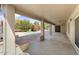 View of the covered patio with brick accents, and view to landscaped backyard at 15406 W Pinchot Ct, Goodyear, AZ 85395
