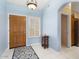 Bright entryway featuring tile flooring, a wooden door, and a shuttered window at 15406 W Pinchot Ct, Goodyear, AZ 85395