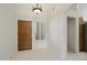 Inviting entryway with tile flooring, chandelier, and a wooden front door and a window with modern shutters at 15406 W Pinchot Ct, Goodyear, AZ 85395
