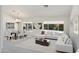 Bright, open-concept living room featuring a modern sectional sofa, dining set, and large windows with backyard view at 15406 W Pinchot Ct, Goodyear, AZ 85395