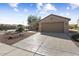 Tan two-car garage with a well-maintained driveway at 16203 W Starry Sky Dr, Surprise, AZ 85374