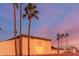 Community building exterior at sunset, featuring palm trees and landscaping at 205 S Higley Rd # 189, Mesa, AZ 85206