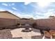 View of the backyard featuring a stone firepit and desert landscaping at 2077 W Tanner Ranch Rd, San Tan Valley, AZ 85144