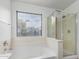 Bright bathroom featuring a soaking tub, a separate shower, and a large window at 2077 W Tanner Ranch Rd, San Tan Valley, AZ 85144