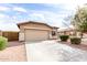 Attractive home with a two-car garage, green bushes, and low maintenance desert landscaping at 2077 W Tanner Ranch Rd, San Tan Valley, AZ 85144