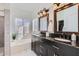 Elegant bathroom with double vanity, soaking tub, and large mirrors at 2407 E Taro Ln, Phoenix, AZ 85050