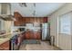 Well-lit kitchen featuring stainless steel appliances, dark cabinets, stone countertops, and tile flooring at 2525 S College Ave # 4, Tempe, AZ 85282