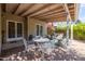 The outdoor patio has stylish seating under a pergola with double doors leading inside the home at 305 W Lewis Ave, Phoenix, AZ 85003