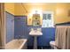Vintage bathroom with blue tiled walls, a pedestal sink, and a window for natural light at 305 W Lewis Ave, Phoenix, AZ 85003