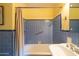 This features a combination shower and tub with blue tile, along with a shower curtain and safety bar at 305 W Lewis Ave, Phoenix, AZ 85003