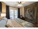 Cozy bedroom with a comfy chair, tapestry wall art, and French doors that provide an outside view at 305 W Lewis Ave, Phoenix, AZ 85003