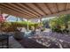 Under a wooden pergola, the patio is a relaxing seating area with brick pavers and lush greenery at 305 W Lewis Ave, Phoenix, AZ 85003