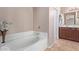 Bathroom with a large tub, double vanity, and wood cabinets at 32211 N Lepa Dr, San Tan Valley, AZ 85144