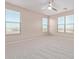 Bright bedroom featuring three windows, ceiling fan and neutral walls at 32211 N Lepa Dr, San Tan Valley, AZ 85144
