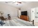 Bright bedroom with wooden dresser, TV, and ensuite bathroom at 3503 E Princeton Ct, Gilbert, AZ 85234