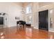 High-ceiling living room with hardwood floors, a grand piano, and a black door at 3503 E Princeton Ct, Gilbert, AZ 85234