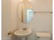 Small bathroom with pedestal sink and oval mirror at 402 N 66Th Ln, Phoenix, AZ 85043