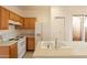Kitchen features wood cabinets, white appliances, and an island at 402 N 66Th Ln, Phoenix, AZ 85043