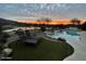 Stunning sunset view over a tranquil lake and inviting pool area at 41717 N Moss Springs Ct, Anthem, AZ 85086