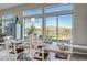 Bright dining room with large windows and mountain views, featuring a wood table and seating for six at 41717 N Moss Springs Ct, Anthem, AZ 85086