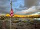 Scenic lake view with American flag and mountain backdrop at 41717 N Moss Springs Ct, Anthem, AZ 85086