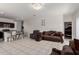 Spacious living room with elegant furniture, tile flooring, and a modern chandelier for a stylish touch at 41917 W Manderas Ln, Maricopa, AZ 85138