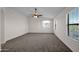 Main bedroom with ceiling fan, large windows, and carpet flooring at 44903 W Buckhorn Trl, Maricopa, AZ 85139