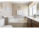 Bathroom featuring a large soaker tub, window, and neutral-colored walls at 4615 W Boston St, Chandler, AZ 85226