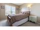 Cozy bedroom with a wooden bed frame, decorative pillows, and natural light from the window at 4615 W Boston St, Chandler, AZ 85226