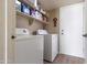 Functional laundry room with a washer and dryer, shelving, and storage for household supplies at 4615 W Boston St, Chandler, AZ 85226