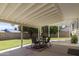 Covered patio with a dining table, chairs, and outdoor rug overlooking the green backyard at 4615 W Boston St, Chandler, AZ 85226