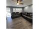 Spacious living room with dark leather couches and wood-look floors at 4821 W Villa Rita Dr, Glendale, AZ 85308