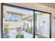 View through sliding glass doors to a stone patio and manicured desert courtyard at 5826 E Indian Bend Rd, Paradise Valley, AZ 85253