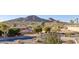 Desert home with mature trees, a circular driveway, and mountain views in the background at 5826 E Indian Bend Rd, Paradise Valley, AZ 85253