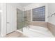 Bathroom with soaking tub, glass shower, and a block window at 6230 W Montebello Way, Florence, AZ 85132